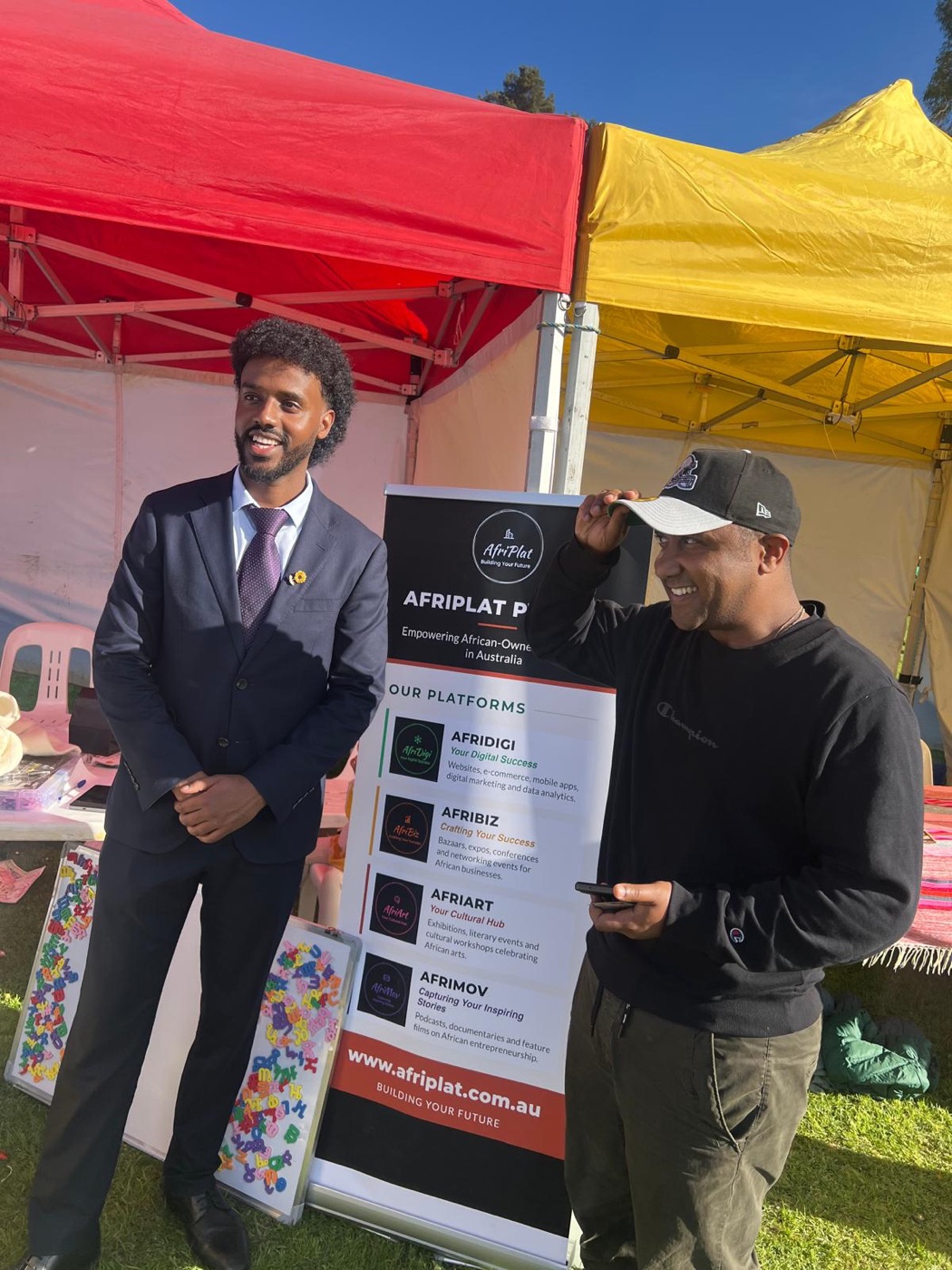 The AfriPlat stall at the Ethiopian New Year celebration, with the platforms banner under red and yellow marquees